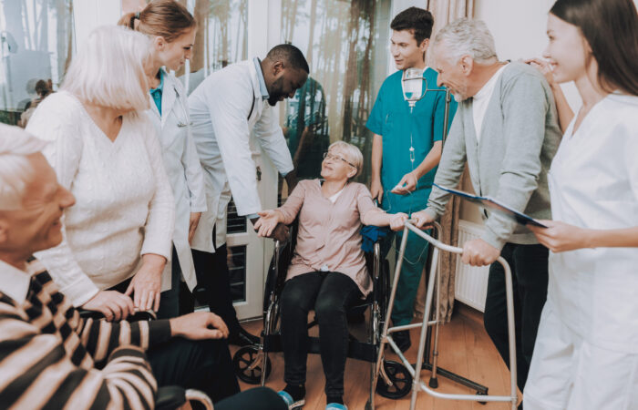 Smiling. Nurse. Medical Staff. Patient. Medical Dropper. Sitting Woman. Male. Doctor in Nursing Home. Patient with Walker. Nursing Home. Man with Crutches. Rehabilitation. Patient on a Wheelchair.