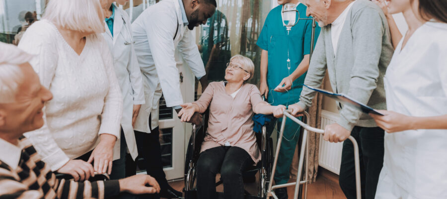 Smiling. Nurse. Medical Staff. Patient. Medical Dropper. Sitting Woman. Male. Doctor in Nursing Home. Patient with Walker. Nursing Home. Man with Crutches. Rehabilitation. Patient on a Wheelchair.