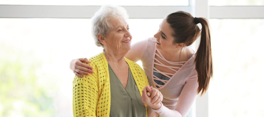 Caregiver with senior woman in nursing home